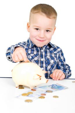 Kind wirft Geldstück in Sparschwein